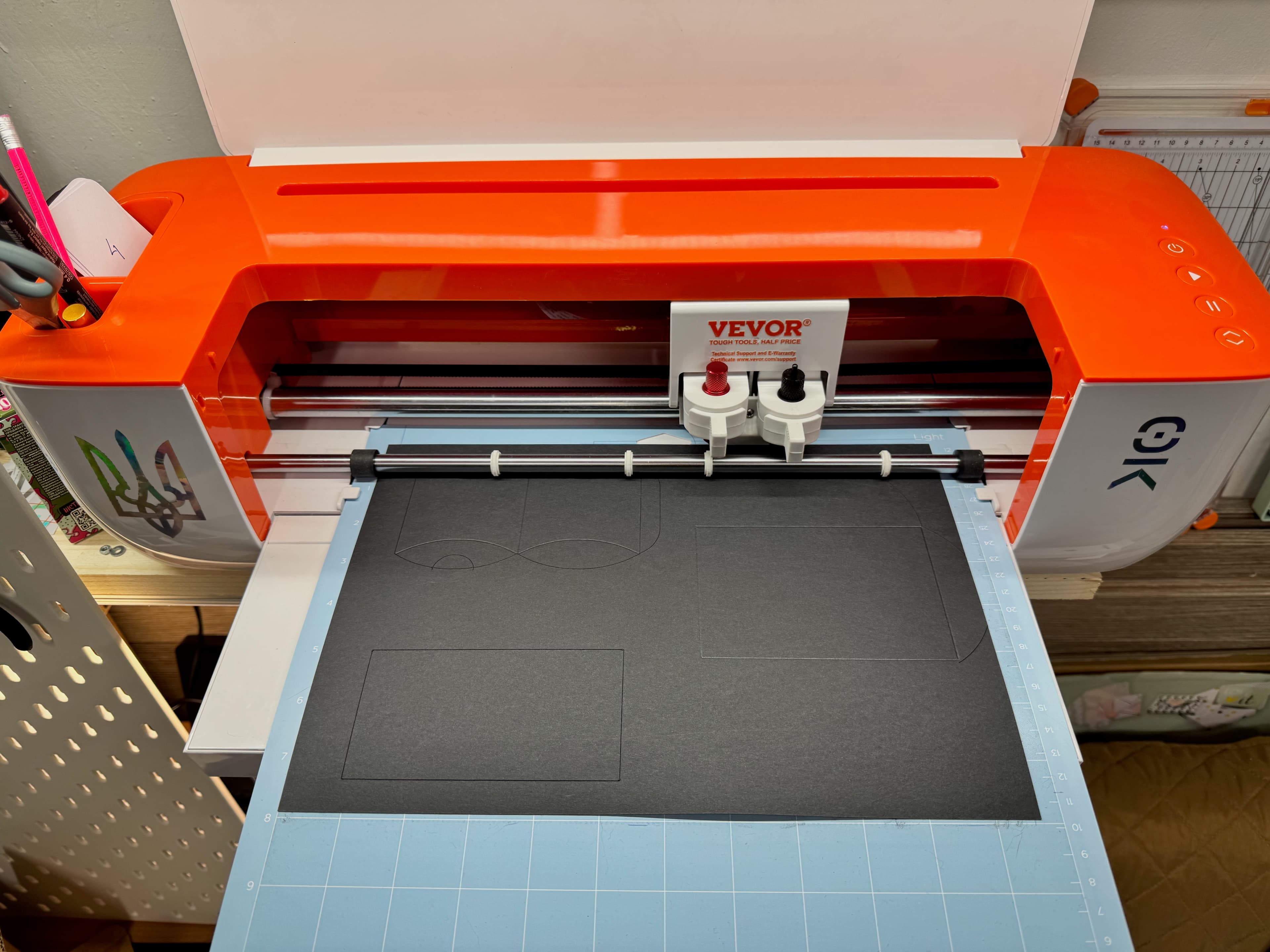 Cardboard inserts being cut on a desktop plotter.